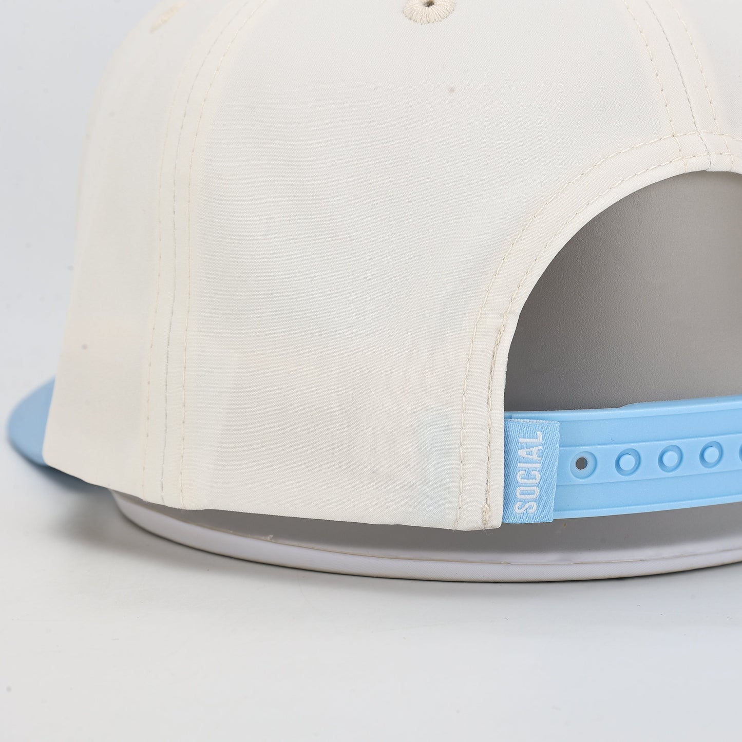White cap with gray interior and blue strap on a white background